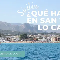 Vista de la playa de San Vito Lo Capo, Sicilia, con aguas azules y montañas al fondo.