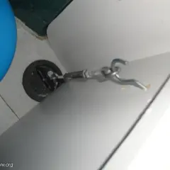 Detalle de cómo anclar muebles camper: un gancho metálico sujeto a un punto de anclaje en la pared de una autocaravana.