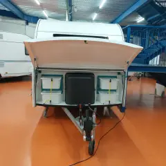 Detalle de la distribución de una furgoneta camper, mostrando compartimentos de almacenamiento y la lanza.