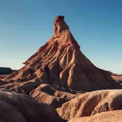 Paisaje desértico en Navarra, ideal para una aventura en camper. Formaciones rocosas erosionadas bajo un cielo azul.