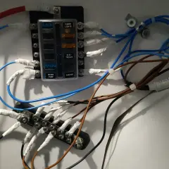 Panel de fusibles con cables conectados, ilustrando la diferencia entre disyuntor y magnetotérmico en un sistema eléctrico.