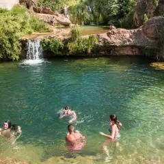 Gente disfrutando de las pozas cerca de Torla, con cascadas y vegetación exuberante.