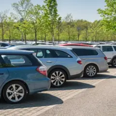 Amplio estacionamiento con coches alineados bajo árboles verdes. Ideal para saber dónde parcheggiare a Granada sin estrés.