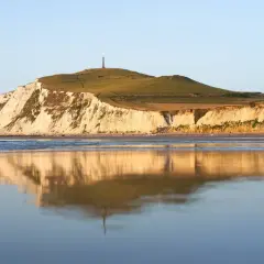 Acantilados blancos y verdes en Cap Blanc Nez, reflejados en el mar tranquilo.