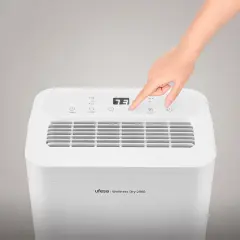 Mano ajustando la velocidad de un deshumidificador Ufesa Wellness Dry 2000. ¡No gasta mucho!