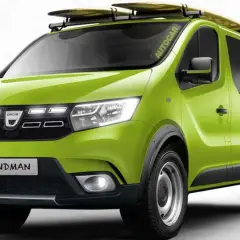 Dacia Sandman verde brillante, lista para la aventura con tablas de surf en el techo y rueda de repuesto.