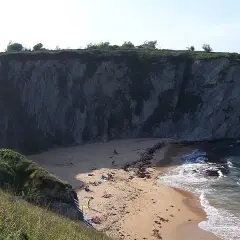 La **playa de la rabia**, un rincón escondido entre acantilados, recibe a unos pocos bañistas que disfrutan del sol y el mar.