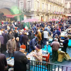 Mercado bullicioso en Palermo, con gente comprando pescado fresco. Un día ajetreado en este lugar, que algunos consideran **palermo peligroso** por su intensidad.
