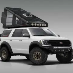 Blanco SUV camper con techo desplegable y paneles solares, listo para aventuras todoterreno.