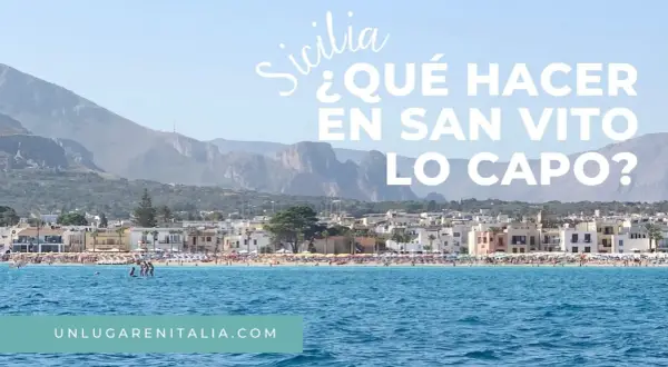 Vista de la playa de San Vito Lo Capo, Sicilia, con aguas azules y montañas al fondo.