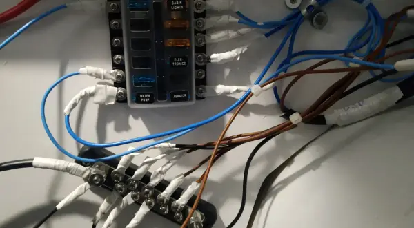 Panel de fusibles con cables conectados, ilustrando la diferencia entre disyuntor y magnetotérmico en un sistema eléctrico.