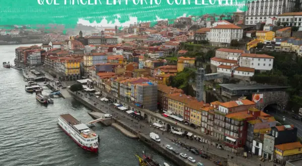 Vista aérea de Oporto con lluvia, con barcos en el río Duero y edificios coloridos.