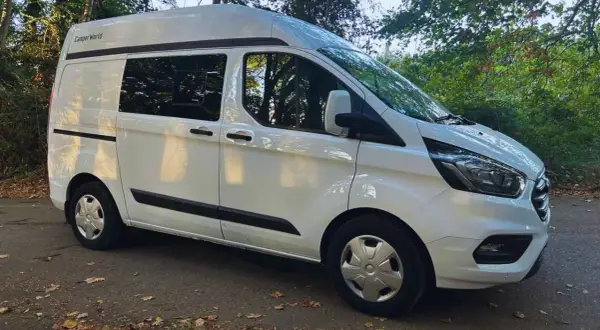 Furgoneta blanca Ford Transit tamaño mediano, lista para la aventura.