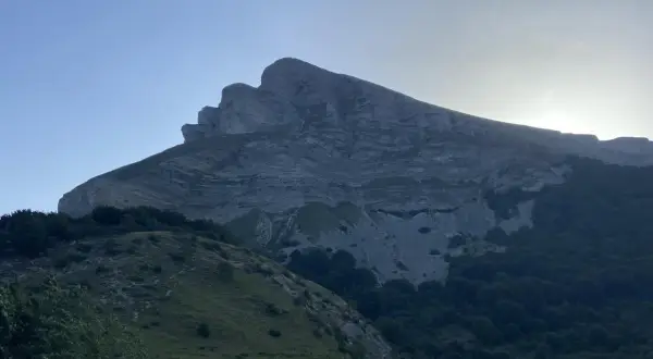 Majestuosa montaña con capas rocosas, silueta del kilometro vertical san donato al amanecer.