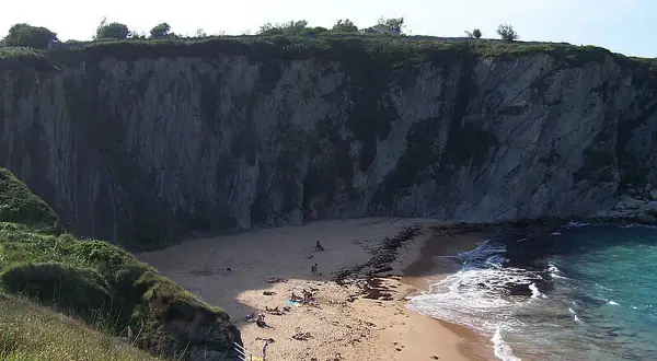 La **playa de la rabia**, un rincón escondido entre acantilados, recibe a unos pocos bañistas que disfrutan del sol y el mar.