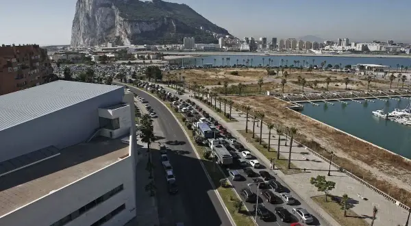 Larga cola de coches para visitar Gibraltar. El Peñón domina el paisaje.