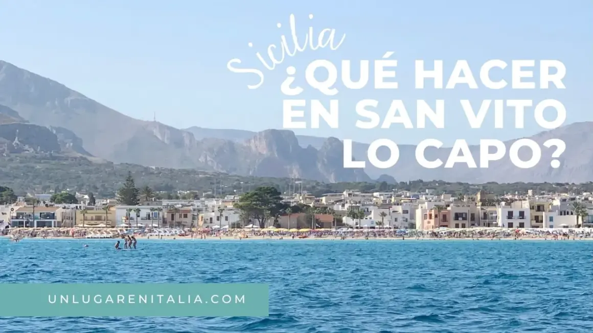 Vista de la playa de San Vito Lo Capo, Sicilia, con aguas azules y montañas al fondo.