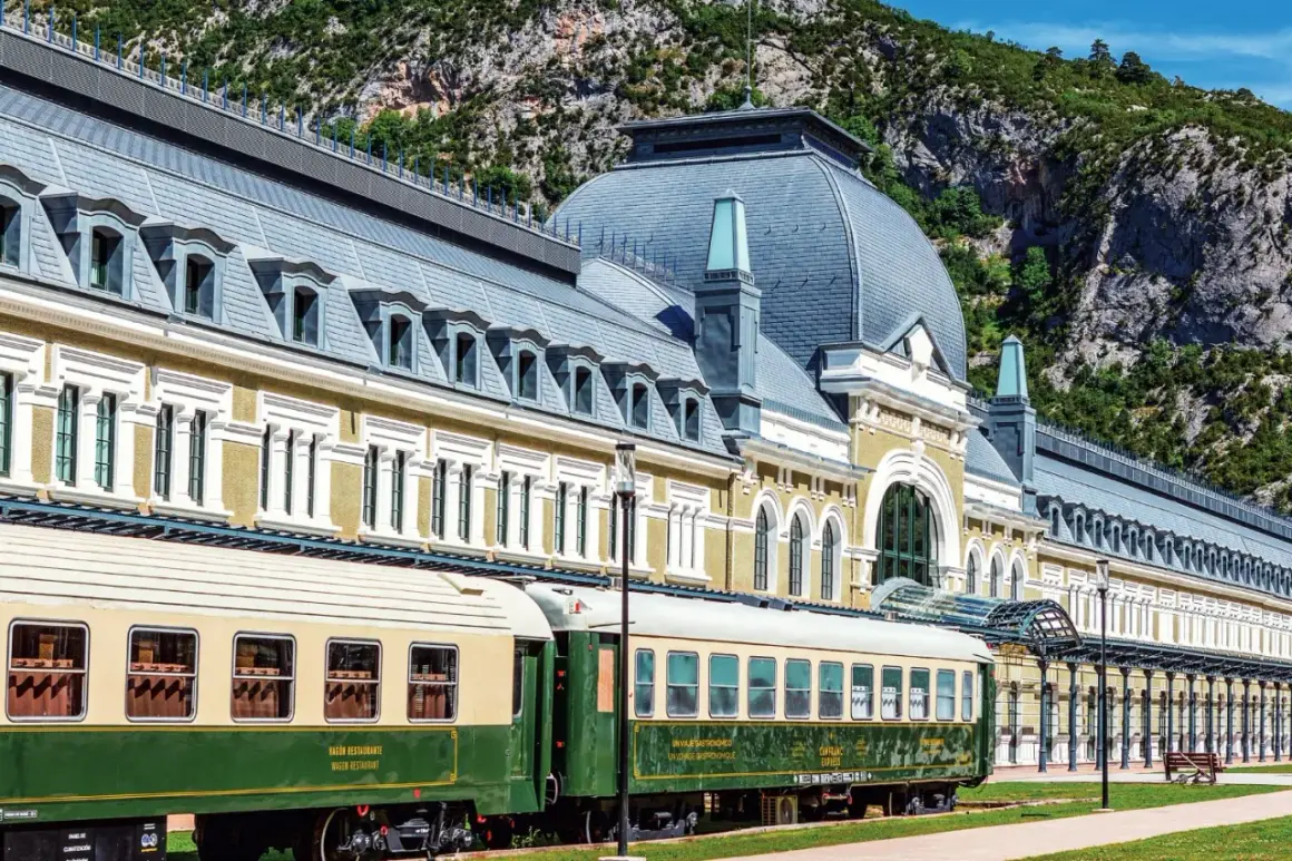 Estación de Canfranc, un lugar ideal donde comer bien en Jaca. Trenes clásicos esperan ante el imponente edificio.