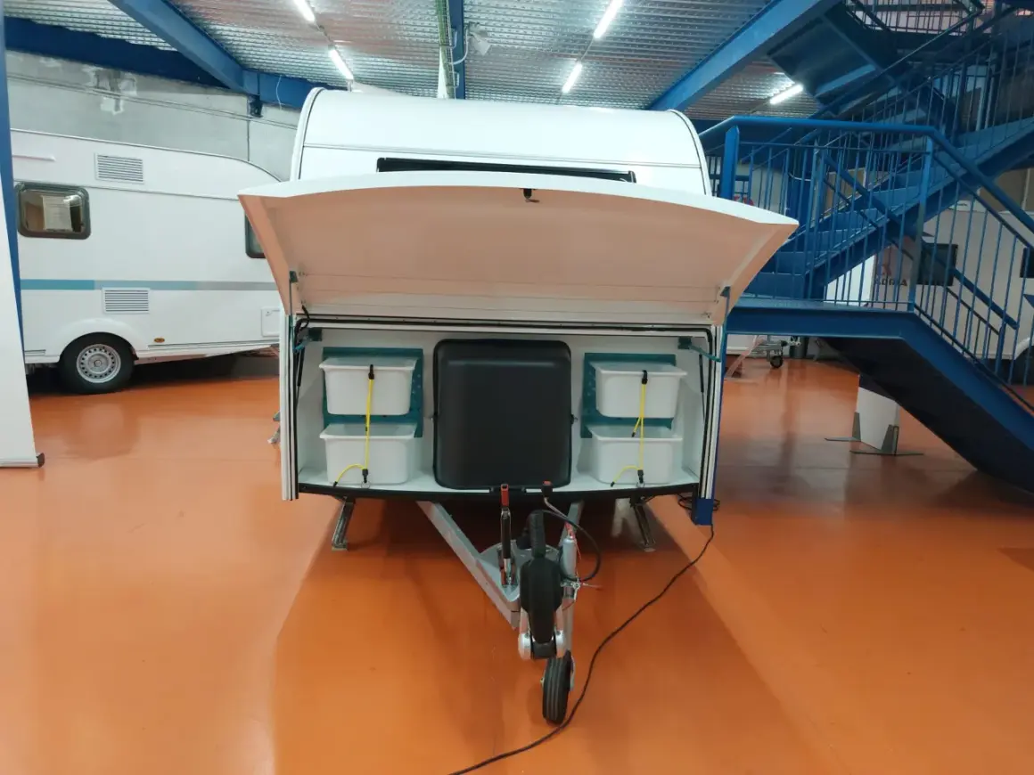 Detalle de la distribución de una furgoneta camper, mostrando compartimentos de almacenamiento y la lanza.