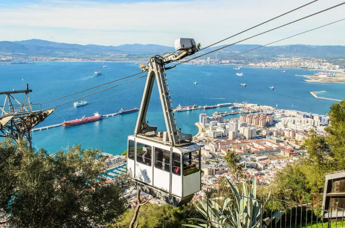 Teleférico en Gibraltar, con vistas al mar y la ciudad. El teleférico, conocido como "Gibraltar Affenfelsen Seilbahn", asciende hacia la Roca.