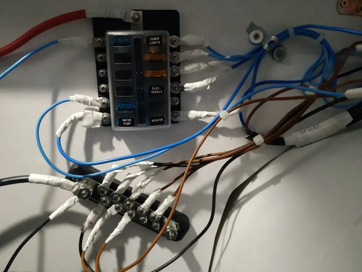 Panel de fusibles con cables conectados, ilustrando la diferencia entre disyuntor y magnetotérmico en un sistema eléctrico.