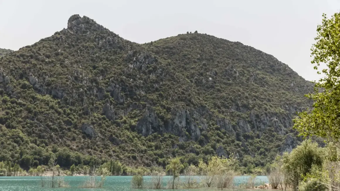 Paisaje del congost de Baldellou con montañas verdes y agua turquesa.