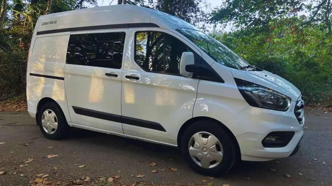 Furgoneta blanca Ford Transit tamaño mediano, lista para la aventura.