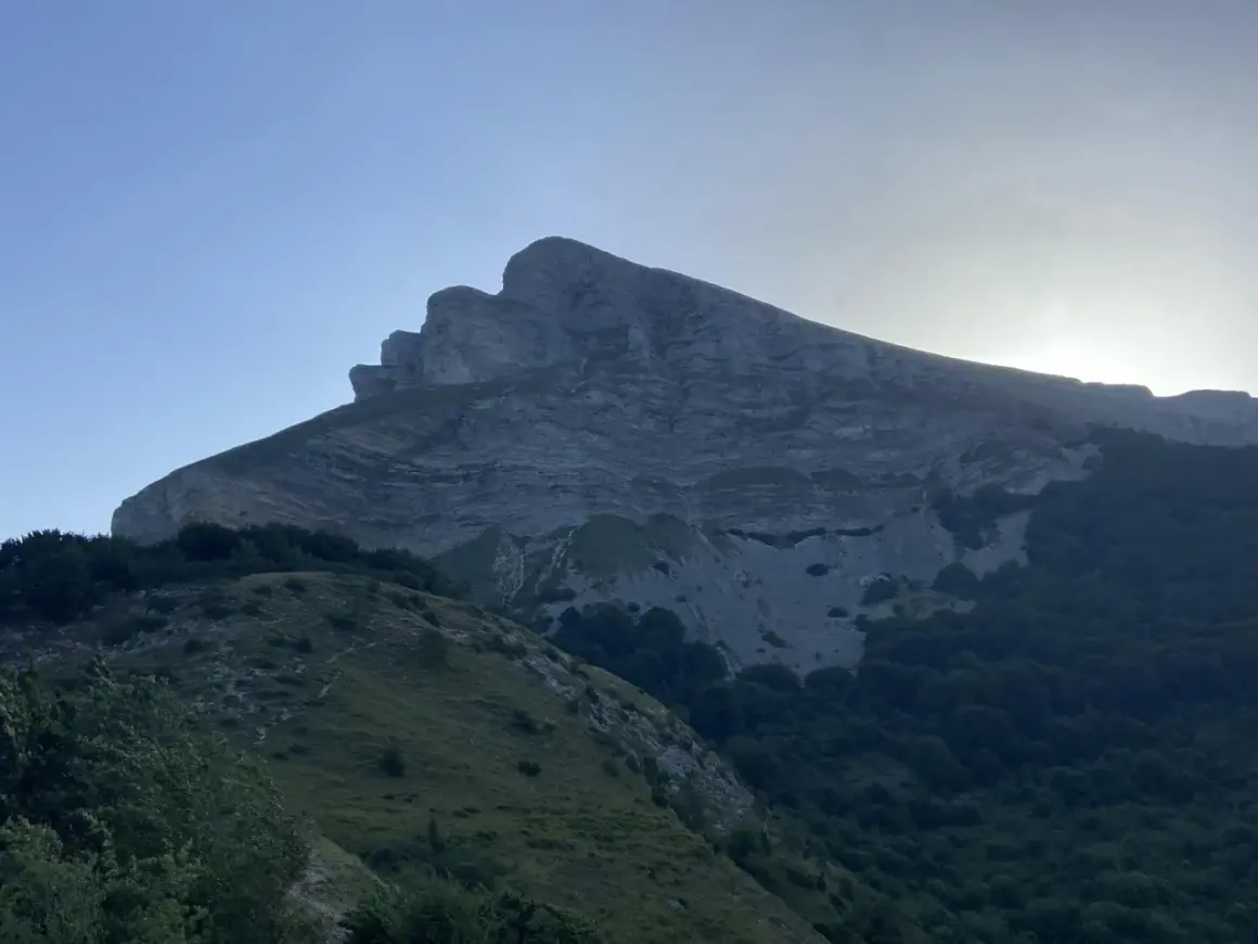 Majestuosa montaña con capas rocosas, silueta del kilometro vertical san donato al amanecer.
