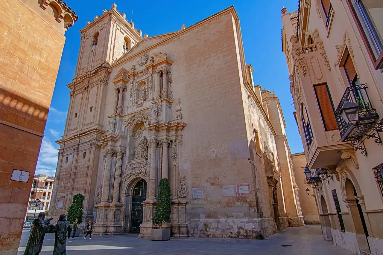 Fachada de la Catedral de Elche, un tesoro de la elche altstadt, bajo un cielo azul intenso.