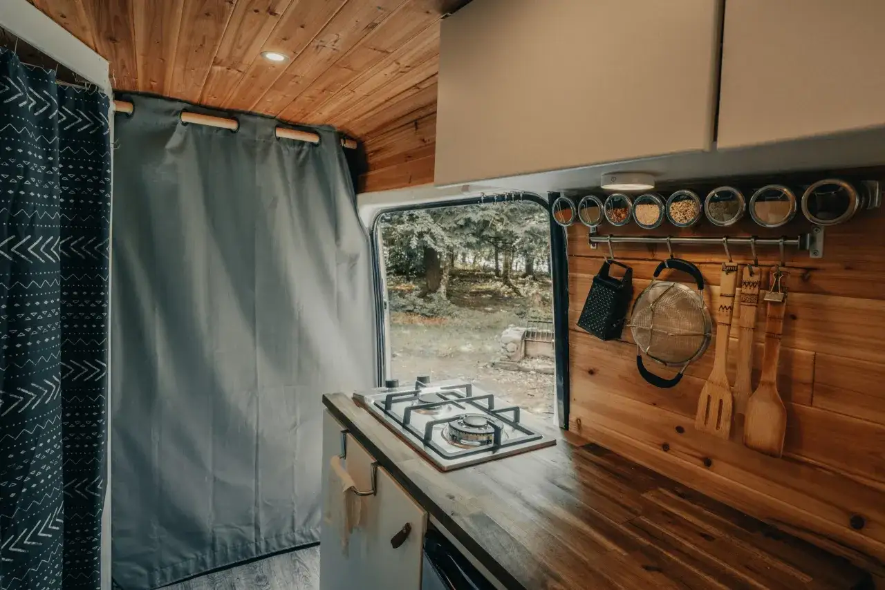 Cocina de camper con estufa, especias y utensilios de madera. &iexcl;Ideas camper para tu pr&oacute;xima aventura!