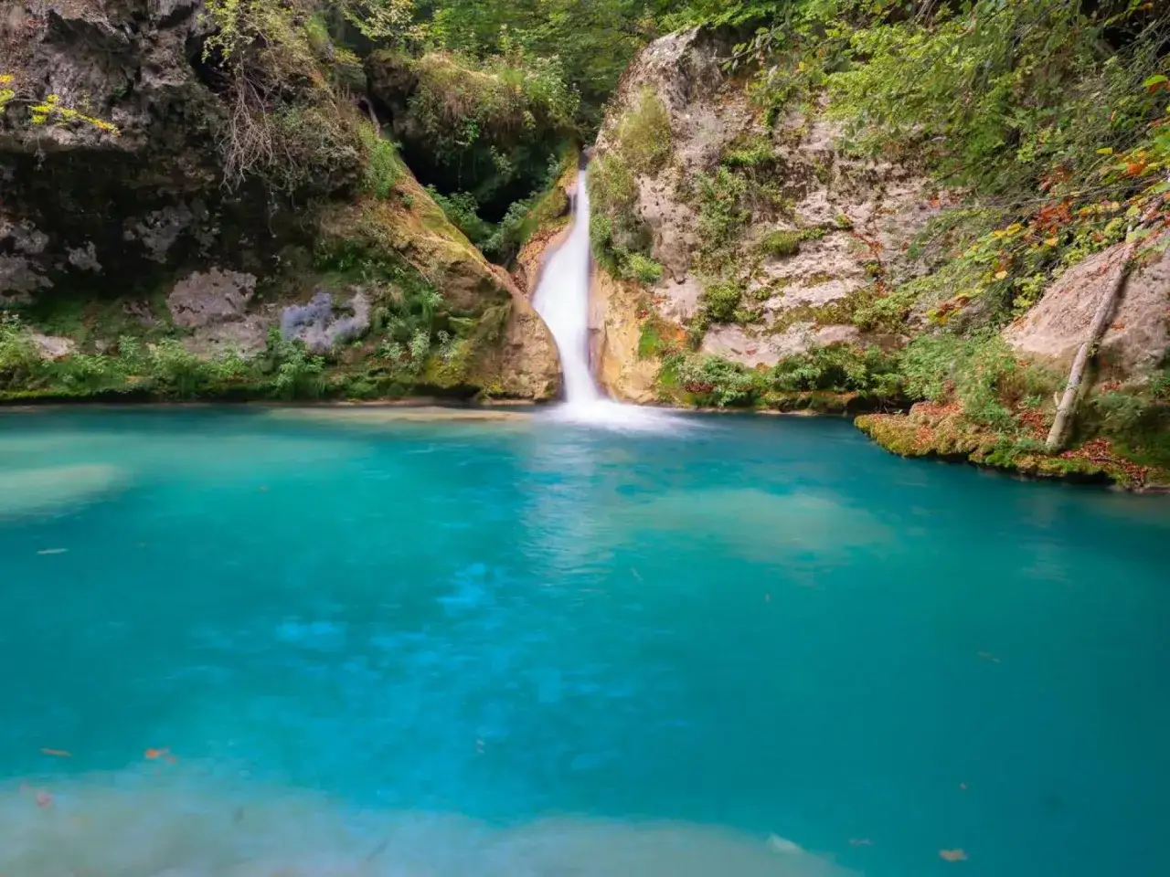Cascada y pozas turquesas cerca de Torla, rodeadas de rocas y vegetaci&oacute;n exuberante. Un para&iacute;so natural.