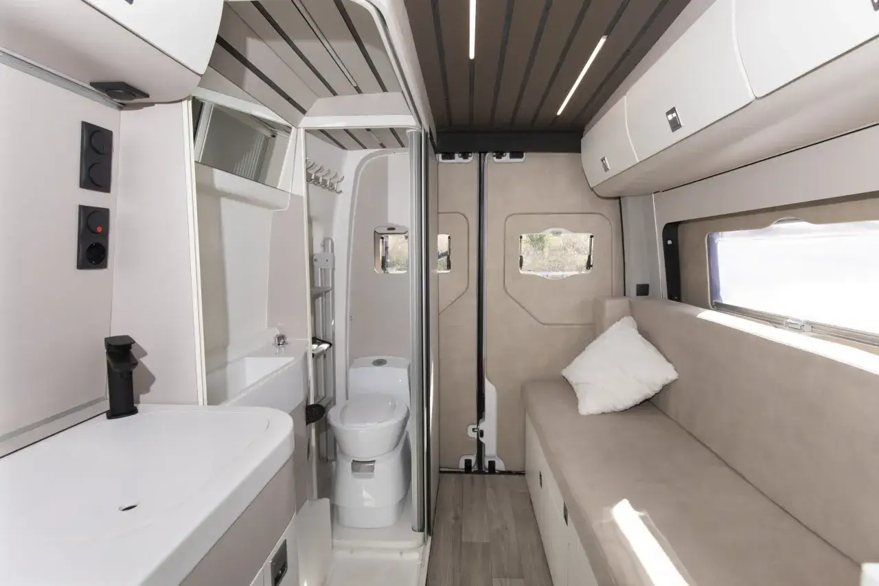 Interior de camper con ba&ntilde;o completo, lavabo y asiento. Ideal para quienes buscan los mejores camper con ba&ntilde;o para sus viajes.