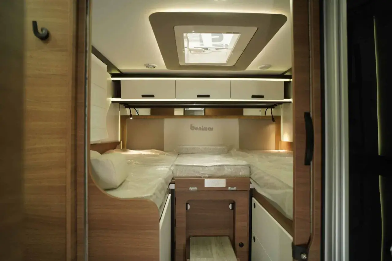 Interior de autocaravana Benimar con camas gemelas, armarios y claraboya. Ideal para solucionar problemas de espacio.