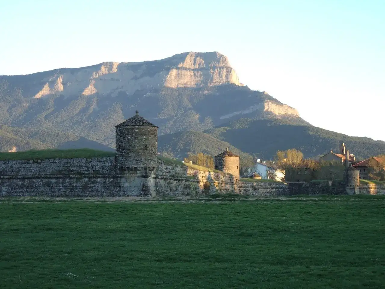 Fortaleza de Jaca con torres y murallas de piedra, bajo una monta&ntilde;a imponente. Un lugar perfecto para un fin de semana en Jaca.