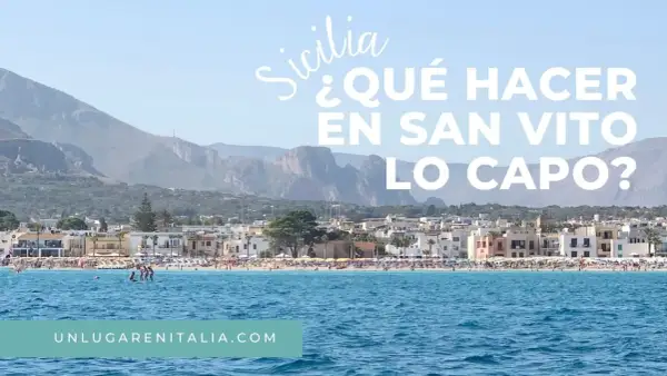 Vista de la playa de San Vito Lo Capo, Sicilia, con aguas azules y montañas al fondo.