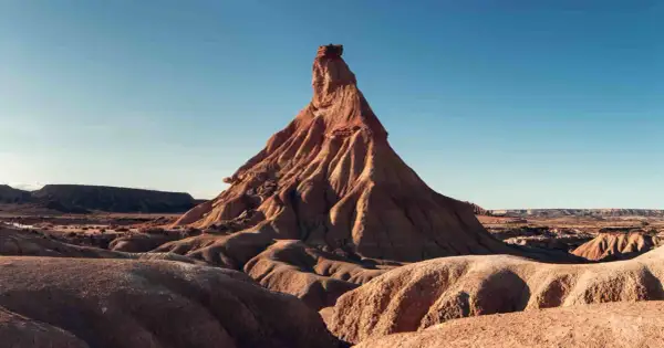 Paisaje desértico en Navarra, ideal para una aventura en camper. Formaciones rocosas erosionadas bajo un cielo azul.