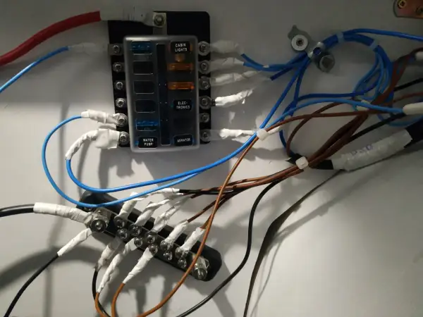 Panel de fusibles con cables conectados, ilustrando la diferencia entre disyuntor y magnetotérmico en un sistema eléctrico.