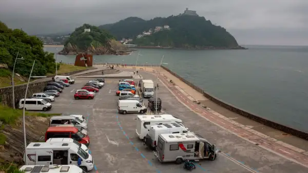Aparcamiento de **San Sebastián en autocaravana**, con vistas al mar y a la montaña.